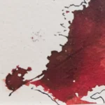 Base de la figura derecha en "Descosido", mancha roja fluida con contorno orgánico.